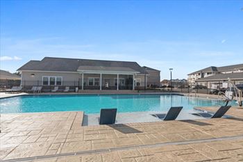 swimming pool with trees and Aurora's clubhouse building in the background